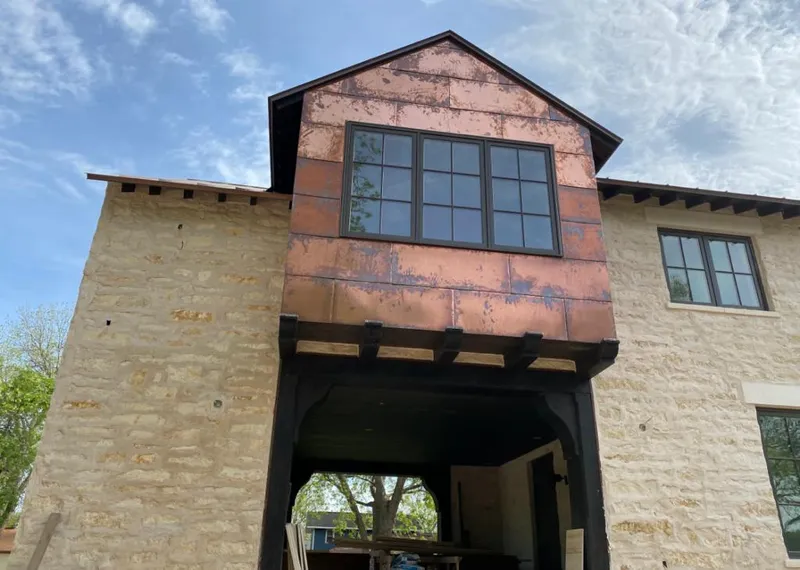 Copper metal panel facade on a stone building for Skylight Installation in Maquoketa